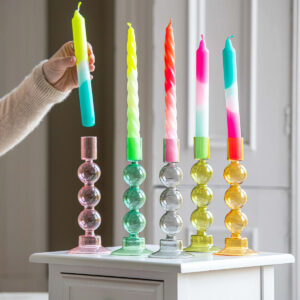 Candles and candlesticks in different colors in the interior design