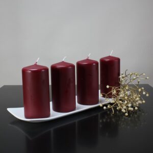 red pillar candles in a candle holder placed on a black table
