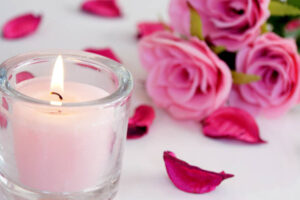 rose smelling candle and pink roses