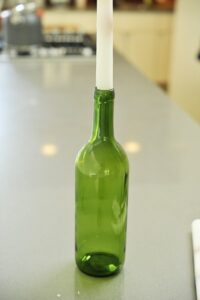 white dripping candle in a green bottle