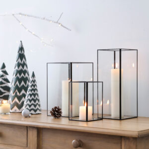 burning pillar candles in square glasses 