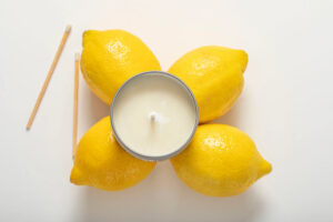 lemon scented candle with lemons aside