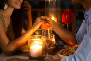 a couple holding hands under candlelight 