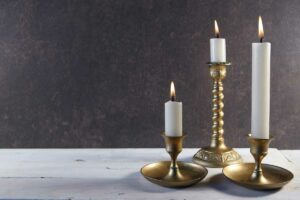 Burning taper candles in metal candleholders 