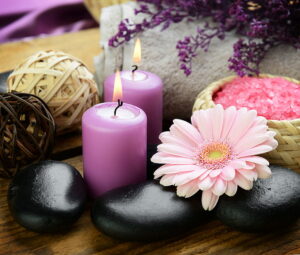 burning candles with flowers and stones 