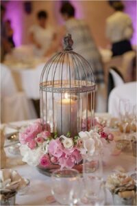 Birdcage with ribbon, flowers and candle 