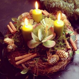 Christmas centerpiece with pillar candles, pine cones, and cinnamon
