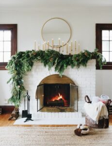 New Year's fireplace decoration with taper candles and evergreen juniper 