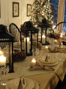 candles, lanterns, and pine cones for Christmas table decoration 
