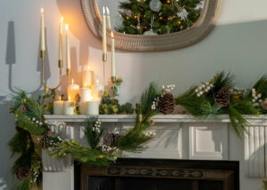 candles with pine and garland for Christmas fireplace decoration
