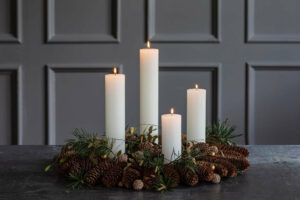 pillar candles with pinecones and greens for Christmas decoration 